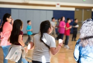 Children participating in physical activities in a gymnasium. 